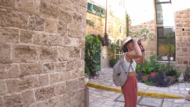 Bir kız, Jaffa şehrinde geziyor ve fotoğraflar çekiyor. Bir kız İsrail 'i dolaşıyor ve blogu için içeriğini vuruyor. A