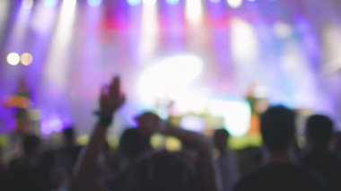 Açık hava festivalinde canlı müzik konserinde alkışlayan ve el sallayan insanların siluetleri. Bulanık etki. Hayranlar alkışlıyor