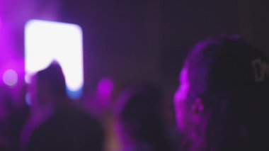 Açık hava festivalinde canlı müzik konserinde alkışlayan ve el sallayan insanların siluetleri. Bulanık etki. Hayranlar alkışlıyor