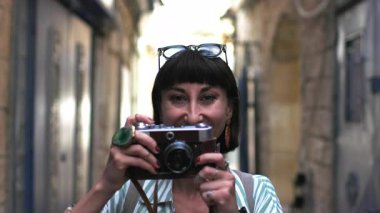 Kameralı çekici bir turist. Kameralı güzel bir kadın güzel yerlerin fotoğraflarını çeker. Kız kaldırır...