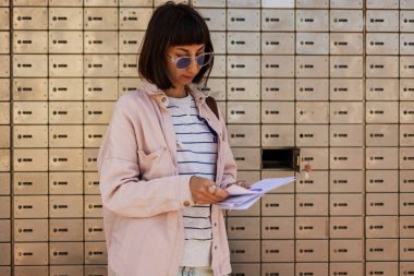 Zarflara yakın çekim. Posta alan kız, yazışmalara bakan kız bildirimi, banka hesap bildirimi.