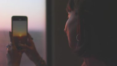 Bir kız trenle seyahat eder ve telefonuyla fotoğraf çeker. Bir blog için içerik oluşturuluyor. Seyahat blogu. Trendeki kız..