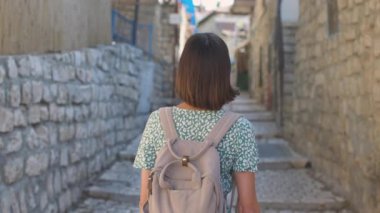 Çekici bir turist eski kasabanın caddesi boyunca yürür ve simgelerin fotoğraflarını çeker. Bir günlük ve sosyal için içerik oluşturuluyor