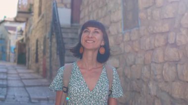 Çekici bir turist eski kasabanın caddesi boyunca yürür ve simgelerin fotoğraflarını çeker. Bir günlük ve sosyal için içerik oluşturuluyor