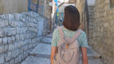 Yavaş çekim, dikiz aynası, kameralı kadın turist tarihi şehir Safed, Israel 'de dar bir sokakta yürüyor, macera.