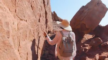 Çölde yürüyen sırt çantalı bir kadın. Çölde gezinti ve yürüyüş. Arkadan bak. Timna Ulusal Parkı. İsrail. Turist