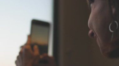 Bir kız tren penceresinden gün batımını fotoğraflıyor. Günlük içeriği oluşturuluyor. İsrail 'de seyahat hakkında bir blog. Trendeki bir kız..