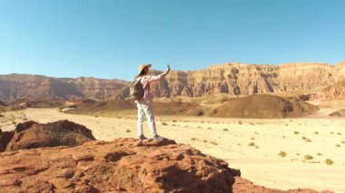 Sırt çantalı bir kız çöl manzarası fotoğrafı çekiyor. Gezgin blogcu. Çöl gezisi. Timna Ulusal Parkı. İsrail. Bir turist.