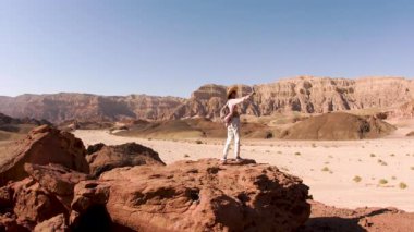 Sırt çantalı bir kız çölde selfie çekiyor. Gezgin blogcu. Çöl yolculuğu. Çölde bir turist.