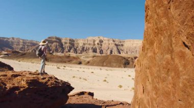 Sırt çantalı genç bir turist çölde yolculuğun tadını çıkarıyor. Sırt çantalı kız..