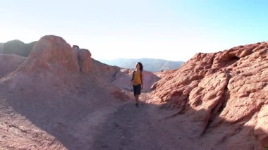 Çölde yürüyüş. Sırt çantalı bir çocuk. Sırt çantasıyla dağlarda yürüyüş yapan bir çocuk. Bir çocuk patikada yürüyor.