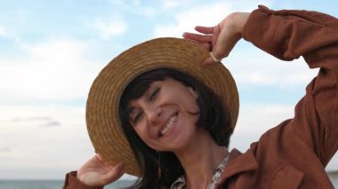 Yağmurdan sonra plajda yürürken şapkalı genç bir kadının görüntüsü. # Kız anın tadını çıkarıyor #