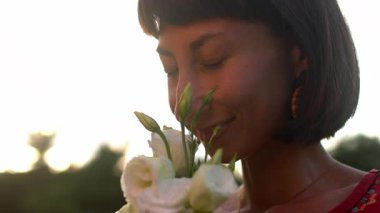 Kız çiçeklerin ve gülümsemelerin kokusunu içine çekiyor. İlk randevu. Bir buket çiçekli kız.
