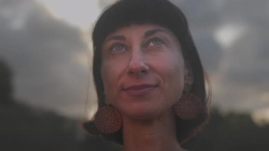 Yazın parkta duran, kısa saçlı, doğal güzellikte bir kadının yakın plan portresi. Açık havada çekici bir kadın..