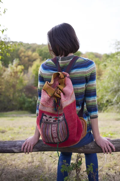 Flickan med ryggsäcken mediterar i skogen. — Stockfoto
