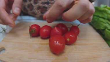 Bir adam domatesleri dilimlemeden önce onları soyar. Tahta kesme tahtasında taze sebzeler. Sağlıklı beslenme.