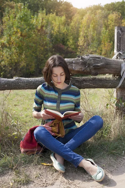 Girl with books and backpack sitting in the Park. — Stock Photo, Image