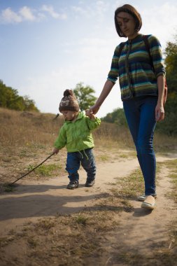 Anne ile çocuk yürüyor.
