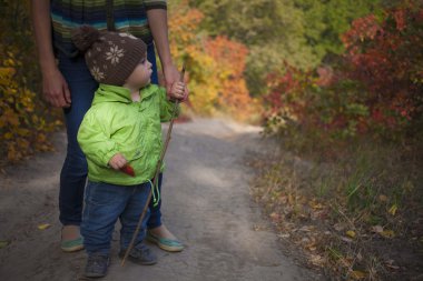 Anne ile çocuk yürüyor.