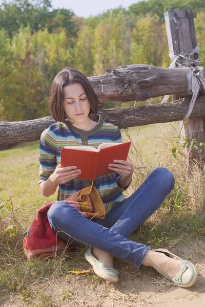 Menina com livros e mochila sentada no parque . — Fotografia de Stock