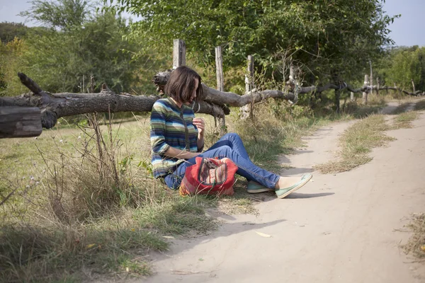 Chica sentada cerca de la carretera . — Foto de Stock