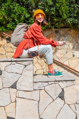 Çekici kız şehirde telefon kullanıyor. Turistler şehri gezer. Macera ve seyahat.