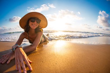 Bir kız okyanus kıyısında güneşli bir havada deniz dalgalarıyla yıkanır. Plaj tatili Yaz havası.