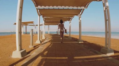 Ölü Deniz 'de dinlenmekten hoşlanan bir kız. Dikiz aynası. Ölü Deniz plajı boyunca koşan bir kadın. İsrail. Deniz kenarında güzel bir kadın.