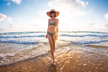 İnce kız denizde eğleniyor. Kumsaldaki genç kız. Tatil ve tatiller. Yaz havası.