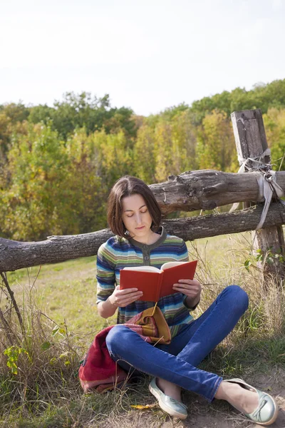 Reiziger meisje zitten met een boek over natuur. — Stockfoto