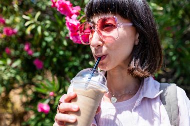 Güzel bir Avrupalı kadın sabah kahvesinin ve gülümsemesinin tadını çıkarıyor. Rahatlıyor, ara veriyor. Mutlu genç bir bayan sokakta yürüyor, dışarıdan kahve içiyor..
