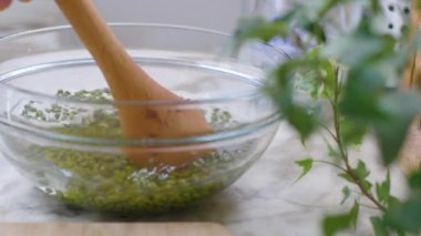 Yeşil gram, tahta kaşıkla karıştırılmış, cam bir kasede. Fasulyelerin hepsini yakın çekim. Sağlıklı beslenme.