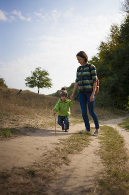 Anne ile çocuk yürüyor.