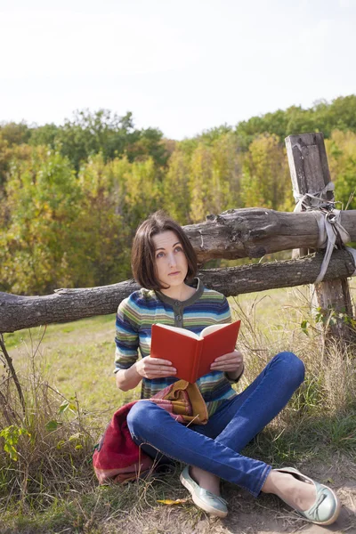 Traveller girl sitting with a book on nature. — Stock Photo, Image