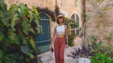 Genç ve çekici bir kadın eski Jaffa şehrinde kamerayla gezip fotoğraf çekiyor. Seyahat ve macera konsepti.