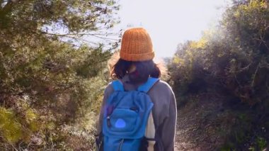 Maceralar ve seyahatler. Sırt çantalı bir çocuk dağ yolunda yürüyor. Çocuklarla seyahat..