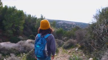 Maceralar ve seyahatler. Sırt çantalı bir çocuk dağ yolunda yürüyor. Dikiz aynası. Seyahatler ve çocuklarla tatiller. Bir çocuk.