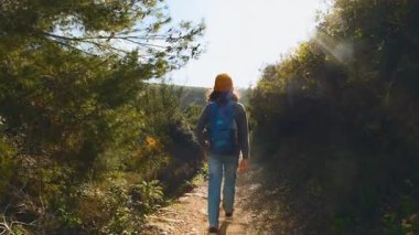 Maceralar ve seyahatler. Sırt çantalı bir çocuk dağ yolunda yürüyor. Dikiz aynası. Seyahatler ve çocuklarla tatiller. Bir çocuk.