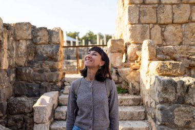 Harabeler arasında şık bir turist gezintisi. İsrail 'de antik taş kalıntıları yakınında bir turist. Beit She'an. Kız seyahat ediyor..