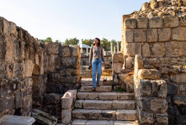 Harabeler arasında şık bir turist gezintisi. İsrail 'de antik taş kalıntıları yakınında bir turist. Beit She'an. Kız seyahat ediyor..