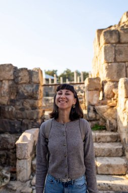 Harabeler arasında gezinen şık bir turistin portresi. Eski taş kalıntıları yakınında bir turist. Seyahat eden bir kız.