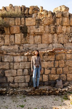 Harabeler arasında şık bir turist gezintisi. İsrail 'de antik taş kalıntıları yakınında bir turist. Beit She'an. Kız seyahat ediyor..