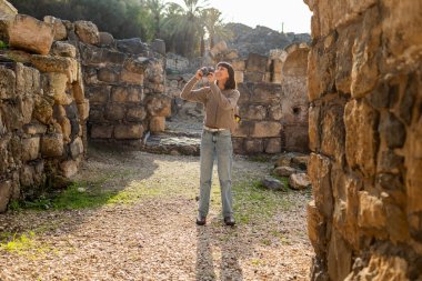 Harabeler arasında şık bir turist gezintisi. İsrail 'de antik taş kalıntıları yakınında bir turist. Beit She'an. Kız seyahat ediyor..