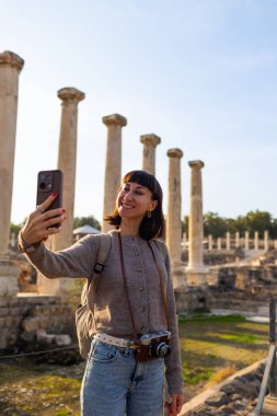 Harabeler arasında şık bir turist gezintisi. İsrail 'de antik taş kalıntıları yakınında bir turist. Beit She'an. Kız seyahat ediyor..