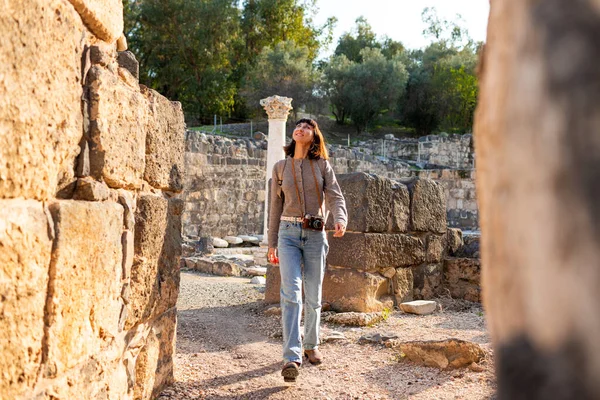 Harabeler arasında şık bir turist gezintisi. İsrail 'de antik taş kalıntıları yakınında bir turist. Beit She'an. Kız seyahat ediyor..