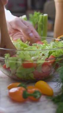 Salata karıştıran ve sıcak bir mutfakta yemek hazırlayan bir şefin yakın çekimi. Salata hazırlığı. Sağlıklı yemek..