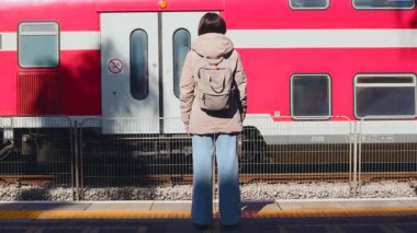 Bir yolcu tren için bekliyor. Şık bir genç bayan platformda tren bekliyor. Trenle yolculuk..
