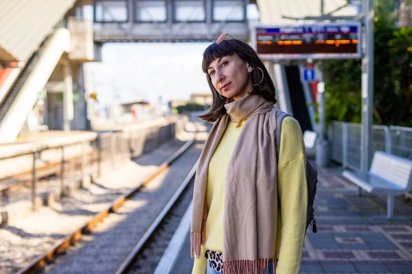 Bir yolcu tren için bekliyor. Şık bir genç bayan platformda tren bekliyor. Trenle yolculuk..