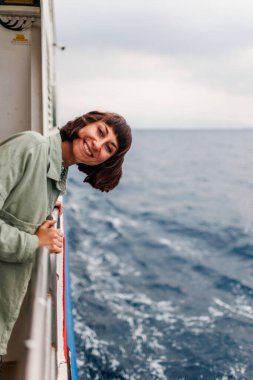 Yaz seyahati sırasında yolcu gemisinde tatil yapan bir kadın. Feribotun açık balkonunda dinlenen bir turistin silueti. Bir kız bir yolcu gemisinin güvertesinde durur ve denize bakar.