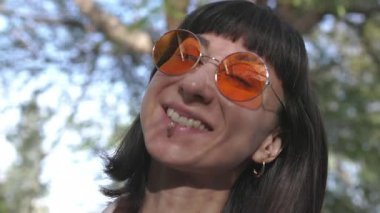 Yüz, güneş gözlüklü mutlu kadın. Genç kız anın tadını çıkarıyor. Gülümse ve insani duygular. Gülümseyen kız.